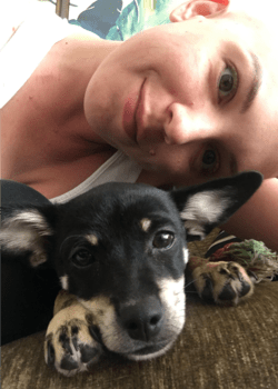 image of a woman smiling next to her puppy